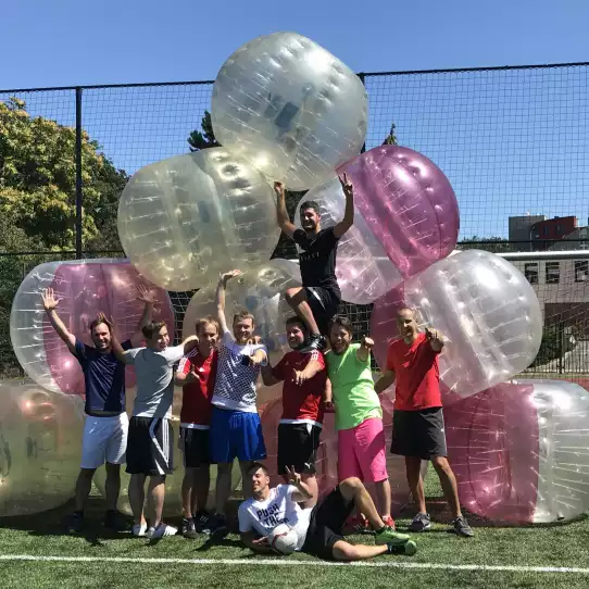 Large group of people after playing bubble football posing in zorb balls.