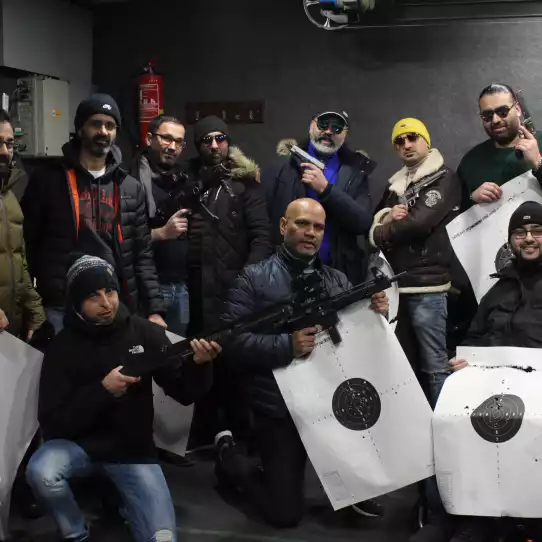 Group of people enjoying a gun range visit during a bachelor party in Prague.