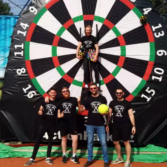 Group of friends after enjoying foot darts during their bachelor party in Prague with the groom to be in the middle of the target.