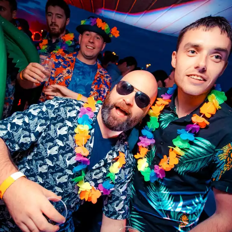 Two guys in Hawaiian shirts enjoying an atmosphere of a Budapest club.