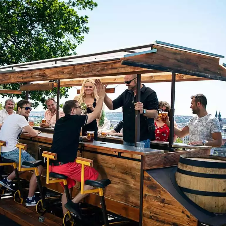 Group of people celebrating on a Prague beer bike.