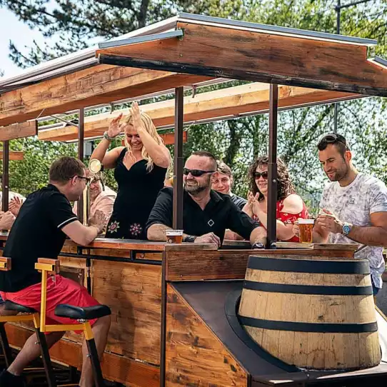 Group of people enjoying a ride on a beer bike in Prague.