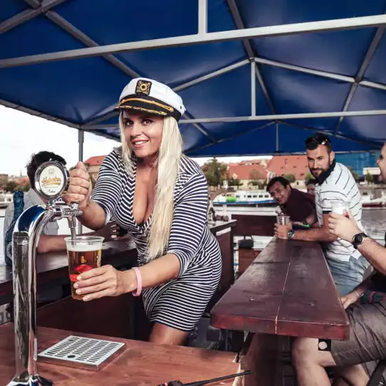Group of people drinking beer on a beer boat in Prague.