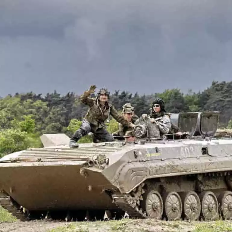 Friends driving a tank during a bachelor party in Prague.