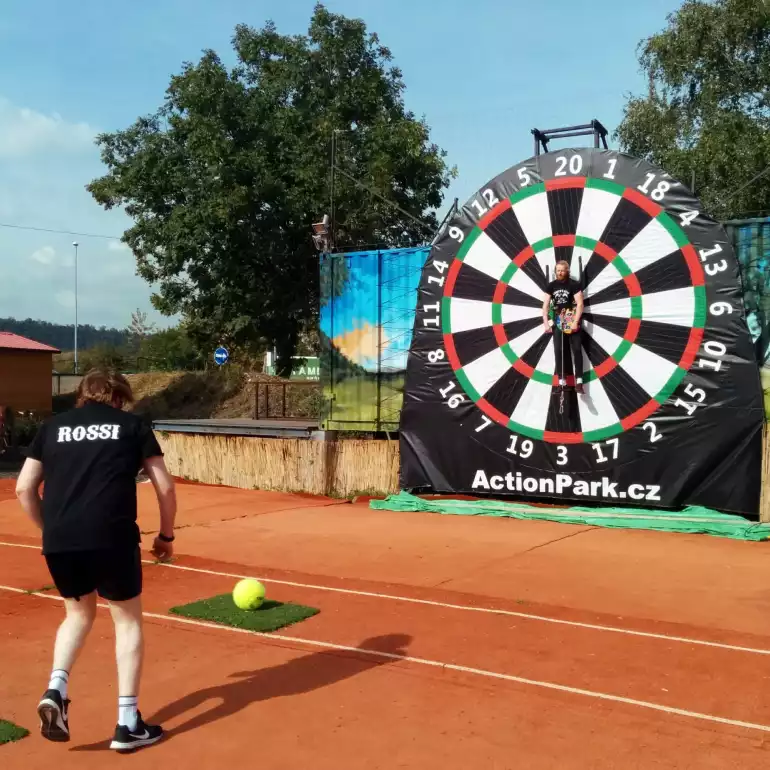 A guy getting ready to kick the ball at the football darts target in Warsaw.