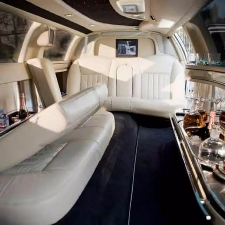 White couch and bar in a Lincoln limousine prepared for a bachelor party.