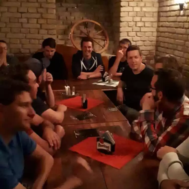 Large bachelor party group enjoying a strip show in a private room of Budapest restaurant.
