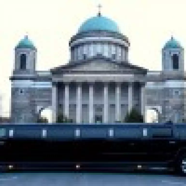 A luxury hummer limo parked outside of a building in Budapest.